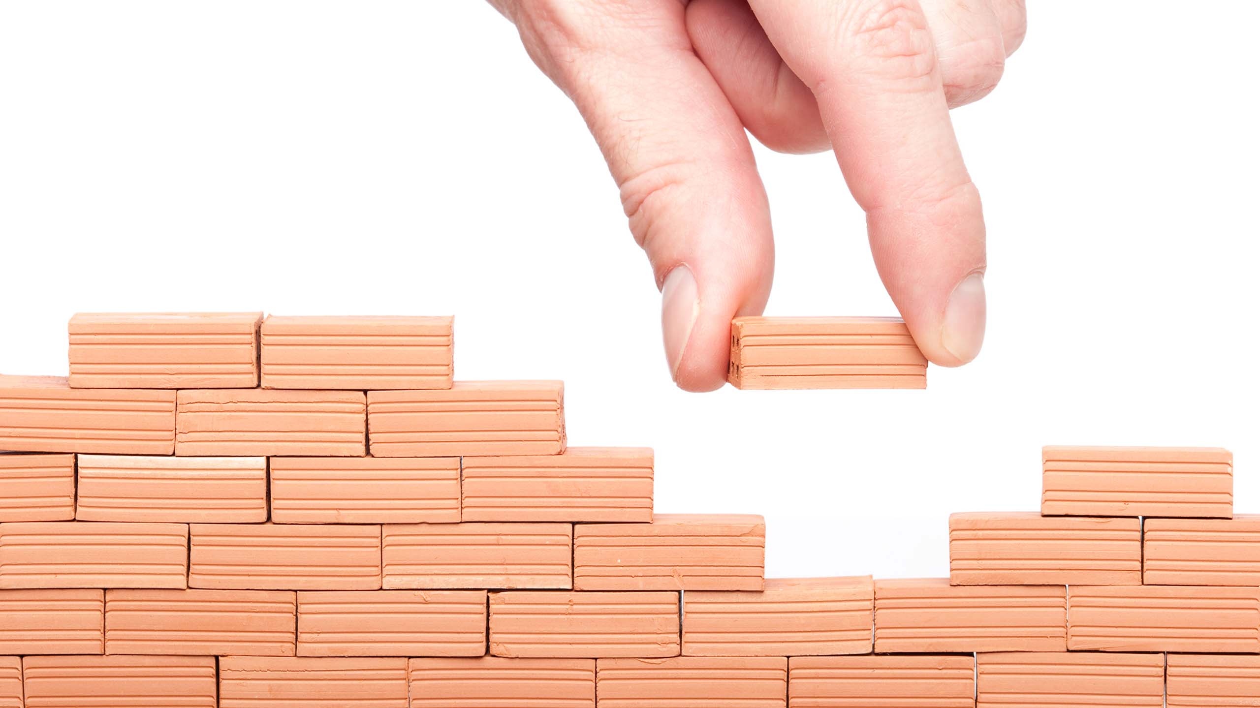 Themenbild: Backsteine mit grosser Hand